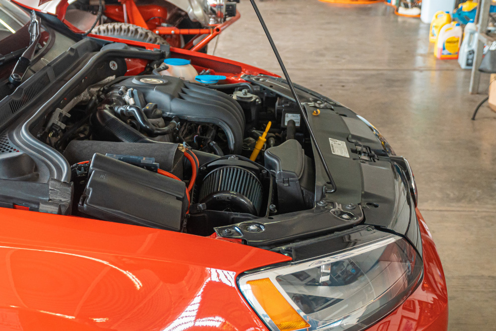 Red VW with the bonnet open showing engine
