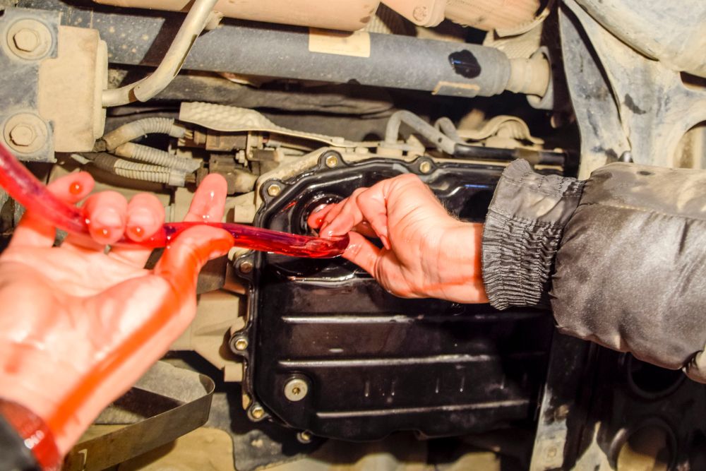 Man changing automatic transmission oil
